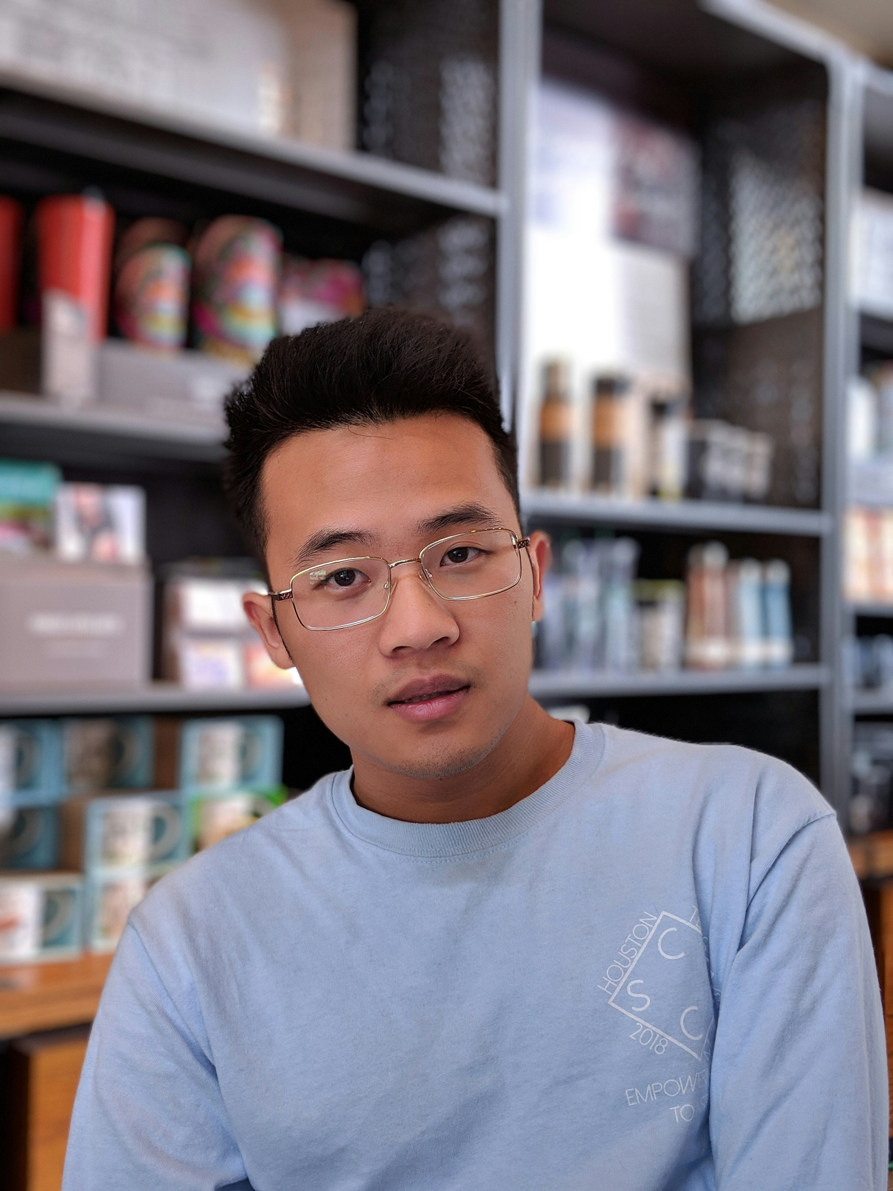 Portrait of a man with glasses wearing a gray shirt.